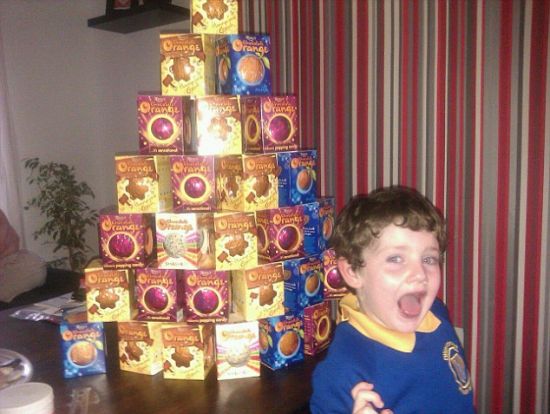 一个男孩正在炫耀自己的战利品,成堆的廉价巧克力。 一个男孩正在炫耀自己的战利品,成堆的廉价巧克力。